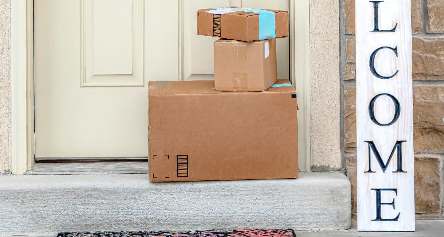 Packages on the doorstep of a home with a welcome sign in Tulsa